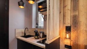 A modern kitchen with a wooden countertop, black faucet, and a coffee maker. - Cosy studio in downtown Gérardmer (Gérardmer)