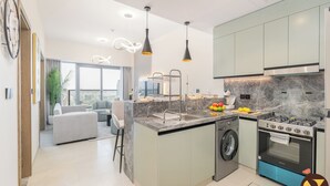 Une cuisine moderne équipée d’un lave-linge intégré, d’une cuisinière et d’un coin repas avec vue.