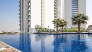 Une piscine offrant une vue dégagée sur un immeuble de grande hauteur en arrière-plan.