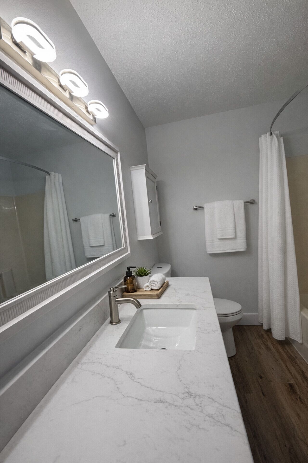 Ein modernes Badezimmer mit einem großen Spiegel, zwei Waschbecken, einer Toilette und einer Duschkabine.