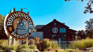 Señal de Roundhouse Brewery con un edificio rústico al fondo.