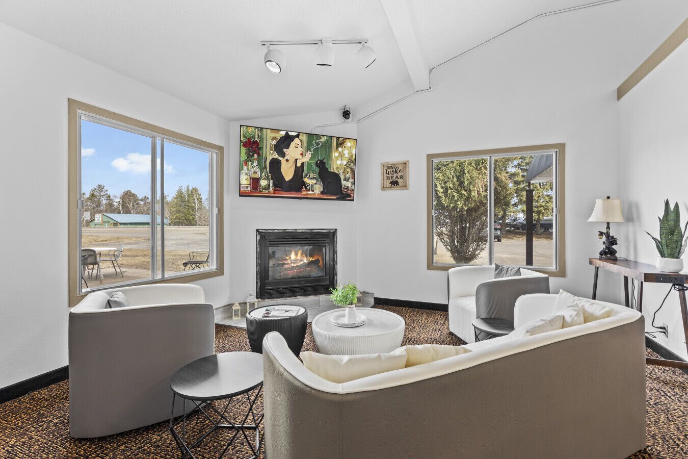 A living room with a fireplace, large windows, and modern furniture.