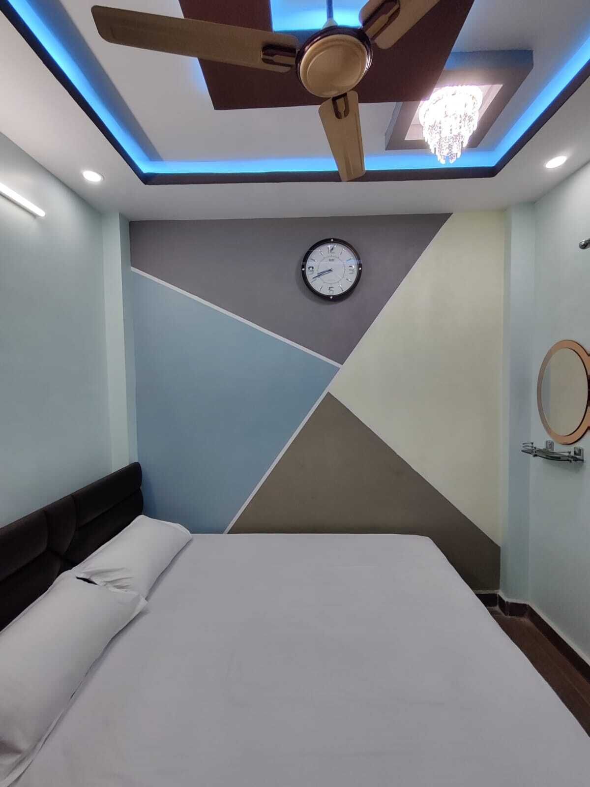 Un dormitorio con cama, ventilador de techo, reloj y candelabro.