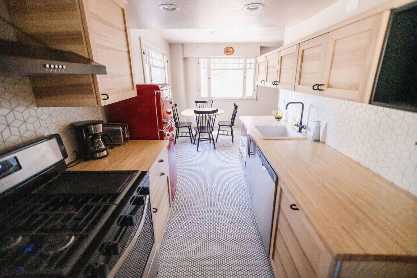 A compact kitchen with a stove, sink, and dining area.
