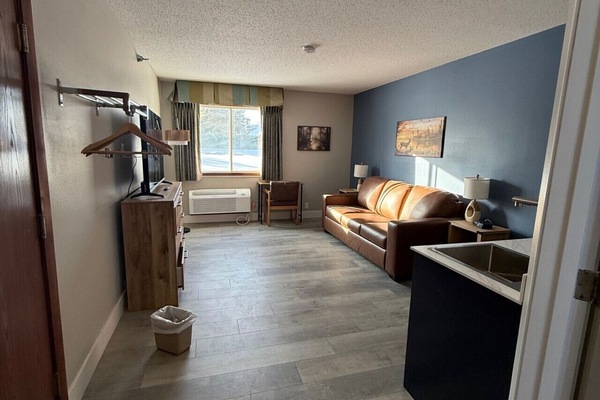 Modern guest lounge offering a leather sofa and workspace.