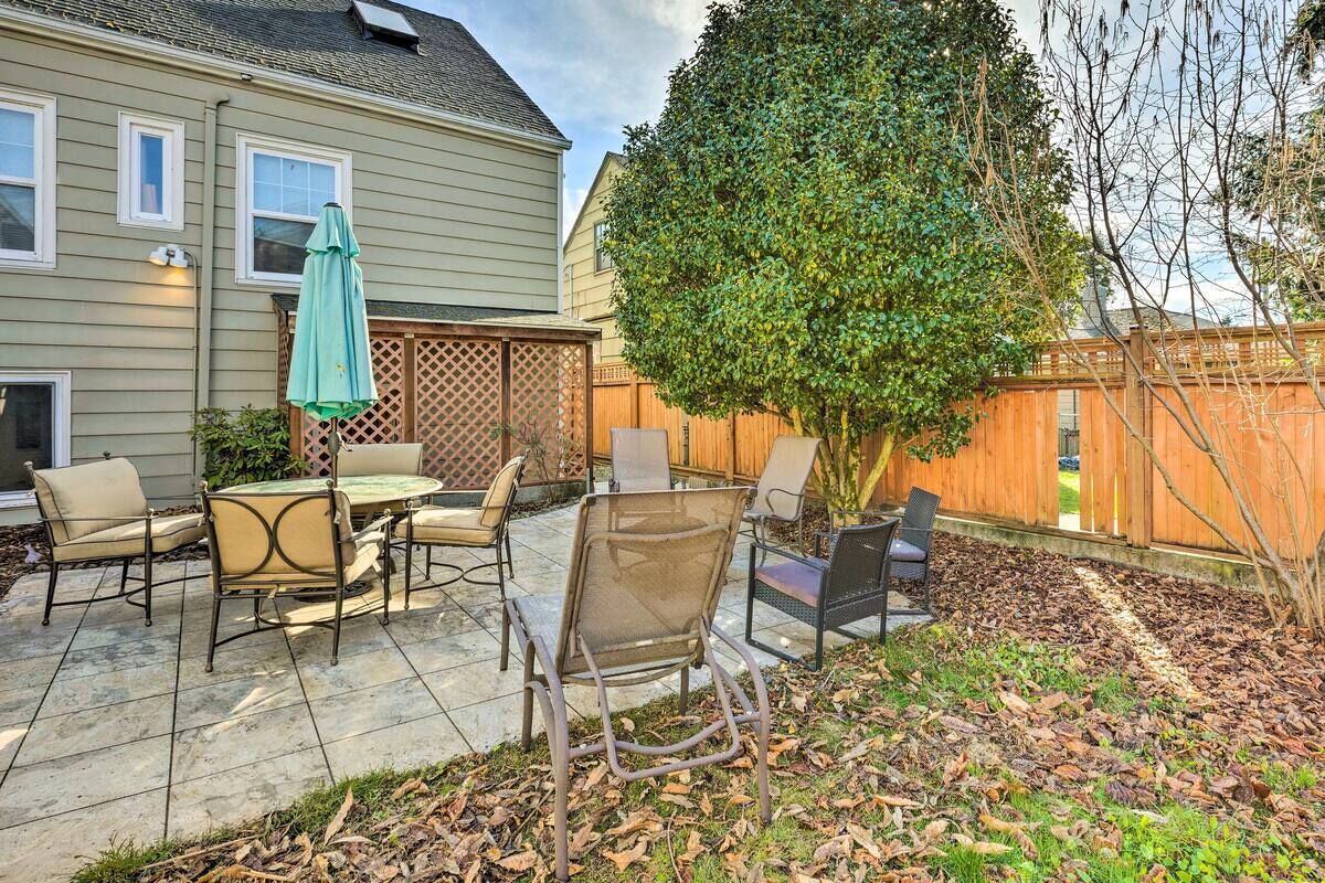 A patio with outdoor furniture, a wooden fence, and a tree.