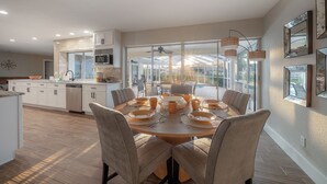A spacious kitchen with a dining area, large windows, and modern appliances. - Waterfront 3BR/2BR Coastal Retreat w/ Pool (Apollo Beach)