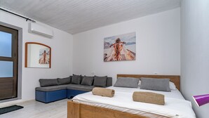Une chambre à coucher moderne avec un lit, un canapé et un tableau au mur.