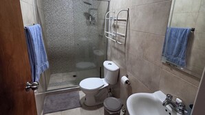 A bathroom with a toilet, sink, and shower.