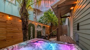 Un espace avec un jacuzzi, une terrasse en bois et un coin salon abrité, ainsi qu’un panneau indiquant « Saint-Augustin ».