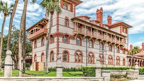 A large, historic building with multiple balconies and arched windows, surrounded by palm trees and a well-maintained lawn. - Designer Spa Retreat Near Historic Downtown! Pets! Luxury Walk to Shops & Dining (St. Augustine)