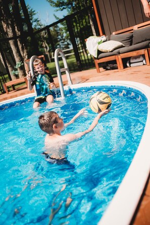 A swimming pool with a child playing with a ball. - Private Estate  getaway near golf, beaches and attractions (New Glasgow)