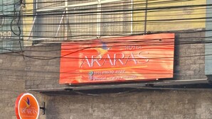 A building with a sign for 'Hotel Araras' and a large glass door entrance.