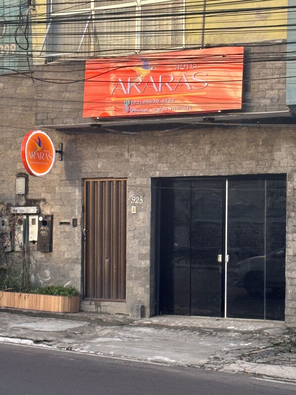 A building with a sign for 'Hotel Araras' and a large glass door entrance. - HOTEL ARARAS (Manaus)