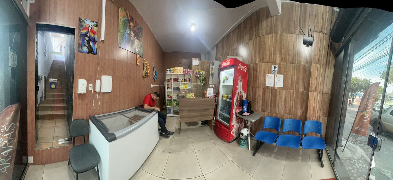 Hall d'albergo con reception, area salotto e frigorifero Coca-Cola.