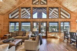 A spacious loft-style room with a high ceiling, large windows, and a fireplace.