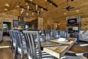 A wooden interior with a dining area, kitchen, and seating area.