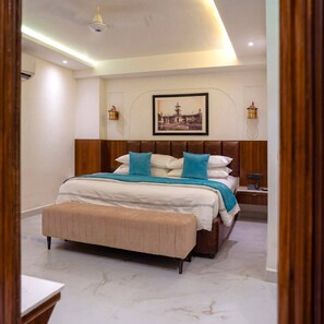 A modern hotel room with a large bed, a bedside table, a nightstand, and a framed picture on the wall. - Prahlad Palace Gwalior (Gwalior)
