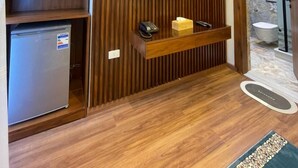 Une salle de bain moderne avec un meuble-lavabo en bois, un téléviseur intégré et un espace douche.