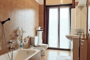 A modern bathroom with a bathtub, toilet, and sink.