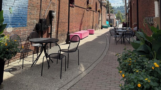 A narrow alley with brick buildings, outdoor seating, and a mural on the left wall. - Charming 2-bedroom house with a river view in wonderful Madison (Madison)