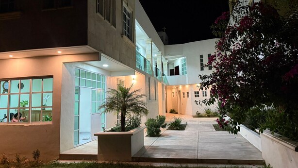 A modern building with a courtyard, large windows, and a well-lit entrance. - Hotel Leilani (Asunción Nochixtlán)