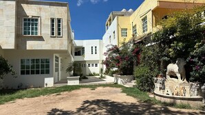 A residential area with modern buildings, a dirt pathway, and a decorative stone sculpture. - Hotel Leilani (Asunción Nochixtlán)