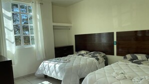 A hotel room with two beds, a wardrobe, a window with curtains, and a tiled floor. - Hotel Leilani (Asunción Nochixtlán)