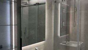 A modern bathroom with a glass-enclosed shower, a large mirror, and a white sink. - Exclusive flat on Lake Como with panoramic views (Como)