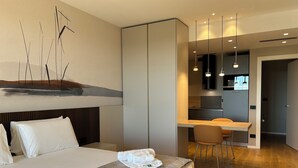 A modern hotel room with a bed, a desk, and a kitchenette. - Exclusive flat on Lake Como with panoramic views (Como)