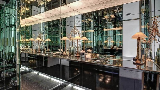 Un interior moderno con superficies reflectantes y candelabros.