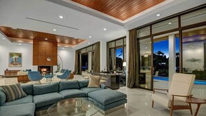 Una sala de estar moderna con un sofá modular, una mesa de centro de vidrio y una chimenea.
