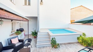 A modern outdoor area with a swimming pool, outdoor seating, and potted plants. - Casa Nueva Cazorla by Ruralidays (Jaén)