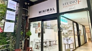 Fachada con letreros que indican 'MINIMAL COFFEE MAKER' y 'STUDIOF SUKHUMVIT'.