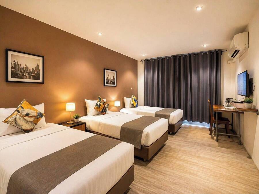 Een hotelkamer met twee bedden, een bureau, een televisie en een stadslandschap op de muur.