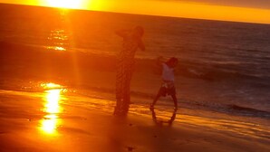 A sunset over a beach with two people silhouetted against the sun. - Delightful 4bedroom house in Plateritos,Canoas d Punta Sal,Contralmirante Villar (Tumbes)