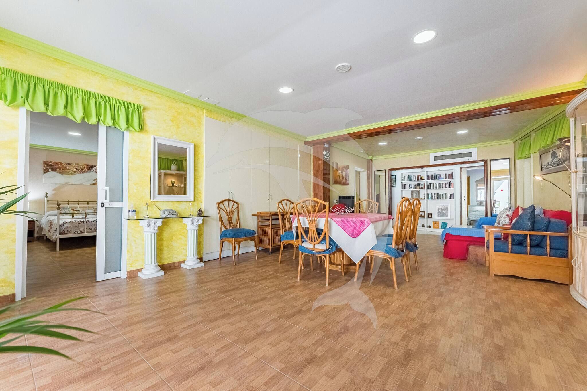 Una habitación amplia con zona de comedor, un sofá y una cama.