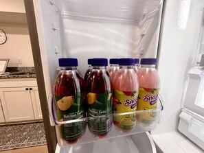 A refrigerator with four bottles of Snapple fruit-flavored beverages.
