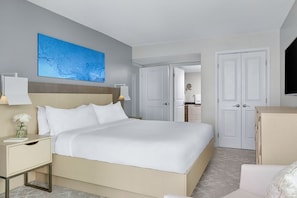 Une chambre d’hôtel avec un grand lit, une table de chevet avec une lampe, une télévision et une armoire.