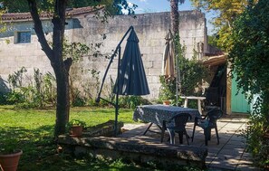 An outdoor patio with a table and chairs, a blue umbrella, and potted plants. - 3 bedroom nice home in Saint-Simon (Saint-Simon)