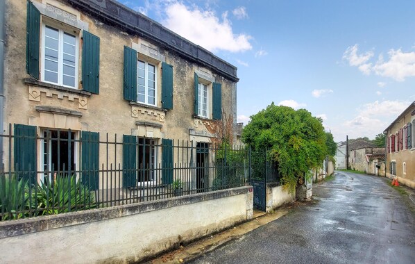 A historic building with traditional architecture, featuring a stone facade, green shutters, and a narrow street. - 3 bedroom nice home in Saint-Simon (Saint-Simon)