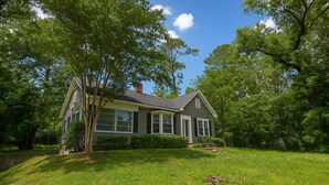 A single-story house with a gabled roof, large windows, and a well-maintained lawn. - Stay on Magnolia Hill 3BR Cottage in Meridian, Mississippi with Southern Charm (Meridian)