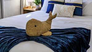 Un dormitorio con una cama grande, cabecera azul y una ventana con cortinas.