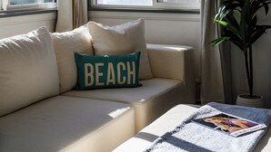 Una habitación con sofá, una mesita, lámpara y planta.