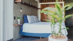 Une chambre à coucher moderne avec un lit, une plante sur la table de chevet et une étagère en bois.
