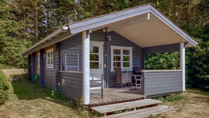 A small, single-story cabin with a porch, a table, and two chairs. - Awesome home in Hasle with house sea view (Hasle)