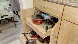A kitchen with wooden cabinets, a countertop, and a table with a floral tablecloth. - Modern living for visit DC/UMD, 2 bedrooms, 4 beds with central AC/heating (Hyattsville)