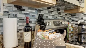 A kitchen counter with a paper towel roll, a bottle of wine, a basket of groceries, and a "Thank You" note. - Modern living for visit DC/UMD, 2 bedrooms, 4 beds with central AC/heating (Hyattsville)