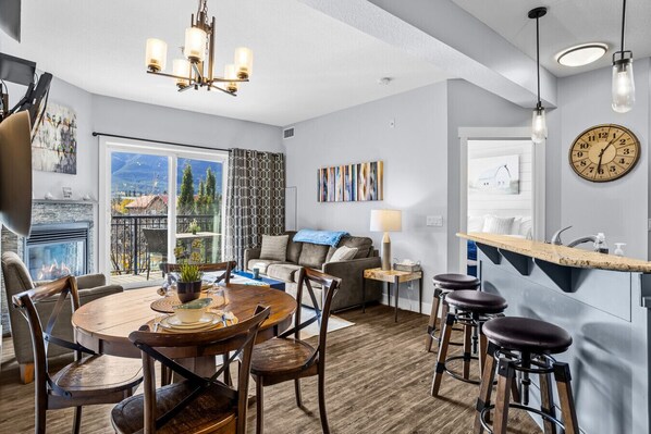 Una sala de estar moderna con comedor, chimenea y vistas al exterior.
