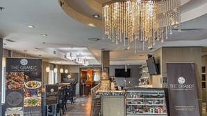 Un intérieur de restaurant moderne avec un bar, un lustre et un présentoir à menus.